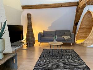 ein Wohnzimmer mit Sofa und Tisch in der Unterkunft Romantic Loft, historic farmhouse, Sauna, Nature walks in Schilde