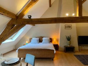 ein Schlafzimmer mit einem großen Bett im Dachgeschoss in der Unterkunft Romantic Loft, historic farmhouse, Sauna, Nature walks in Schilde