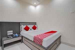 a bedroom with a large bed with red pillows at Hotel O Dhiman Residency in Mumbai +27 photos