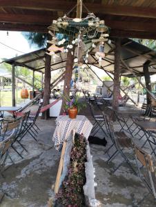 a patio with a table and chairs and a chandelier at Eco Camping - Home-tent in Can Gio