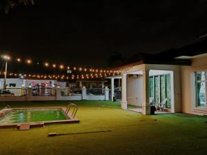 a building with a swimming pool at night at Private Pool KTV Family Villa 3R 12Pax by I Housing in Kampong Solok Haji Dollah