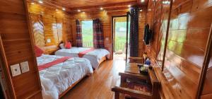 a bedroom with two beds in a wooden cabin at Rose Farm Sa Pa in Sapa +7 photos