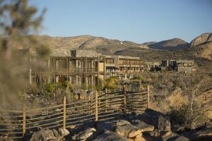 ein altes Gebäude auf einem Hügel mit Bergen im Hintergrund in der Unterkunft Alila Jabal Akhdar in Al Khuţaym