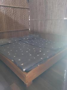 a bed with a blue sheet on top of it at Eco Camping - Bamboo House in Can Gio