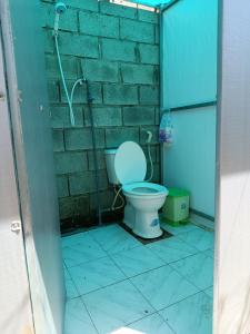 a bathroom with a toilet and a brick wall at Eco Camping - Bamboo House in Can Gio