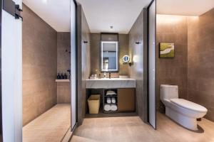 une salle de bains avec toilettes et lavabo dans l'établissement Atour Hotel Yantai Bajiaowan University Town, à Yantai