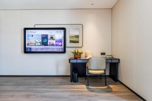 Cette chambre comprend un bureau et un ordinateur mural. dans l'établissement Atour Hotel Yantai Bajiaowan University Town, à Yantai