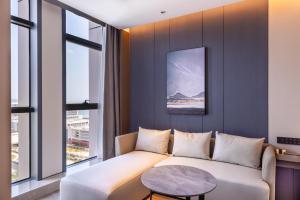 un salon avec un canapé et une table dans l'établissement Atour Hotel Yantai Bajiaowan University Town, à Yantai