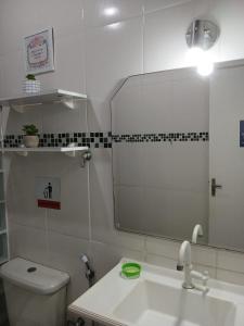 a bathroom with a sink and a toilet and a mirror at Quarto Privado Cama Casal ou Individual Aeroporto in Rio de Janeiro