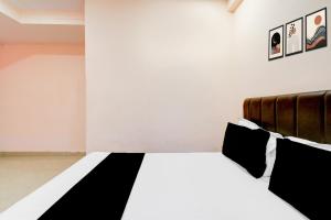 a bedroom with a bed with black and white sheets at Super Hotel O Chandanagar Formerly Nakshatra in Lingampalli