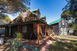 a log cabin with a deck and a barn at The Sea Shack in Waratah Bay