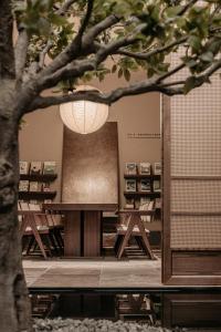 Atour Hotel Shanghai North Bund Riverside International Plaza في شانغهاي: غرفة بطاولة وكراسي وشجرة