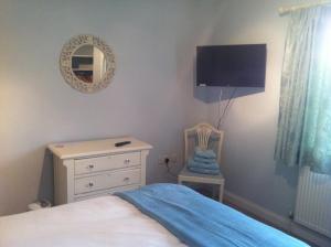 a bedroom with a bed and a dresser and a mirror at East Dunster Deer Farm B&B in Tiverton +15 photos