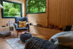 a living room with a blue chair and a chair at Mountain Retreat Stars Peak in Bačić Duliba