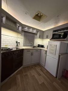 a kitchen with white cabinets and black appliances at E & L Caravan Retreat in Ingoldmells