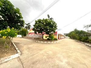 an empty street with trees and a building at OYO 75583 Fut Fit Fo Fai Inn Hotel in Kanchanaburi