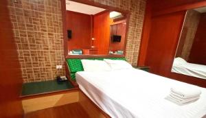 a bedroom with a white bed and a mirror at OYO 75583 Fut Fit Fo Fai Inn Hotel in Kanchanaburi