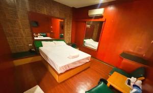 a small room with a bed and a mirror at OYO 75583 Fut Fit Fo Fai Inn Hotel in Kanchanaburi +18 photos
