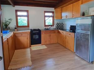 a kitchen with wooden cabinets and a stainless steel appliance at Faré blue lagoon in Moorea