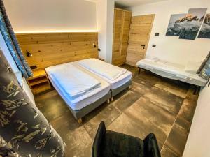 Cesa Bernard - Apartment Cima 12 e new Apartment Fraine في بوتسا دي فاسّا: غرفة نوم بها سرير وكرسي