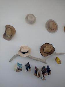 a white wall with hats and photos on it at Hotel Mantalena in Antiparos Town