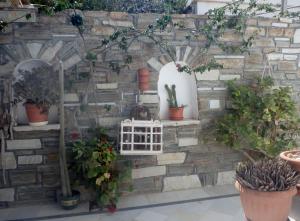 a stone wall with potted plants on it at Hotel Mantalena in Antiparos Town
