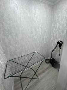 Una cama de alambre en una habitación con una pared en Апартамент, en Uralsk