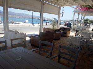 a restaurant with chairs and tables and a view of the water at Hotel Mantalena in Antiparos Town