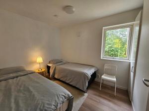 a bedroom with two beds and a window at Vacation home near lake and nature in Munkedal