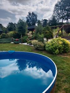a blue swimming pool with the reflection of a yard at Agroturystyka pod Baranią Gorą in Kamesznica +78 photos