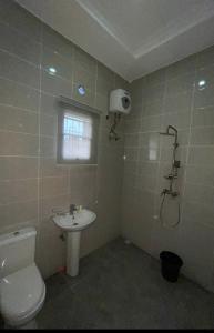 a bathroom with a toilet and a sink at Roak Hotels and Apartments in Abuja +13 photos