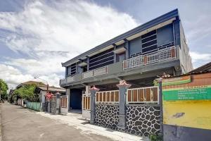 een gebouw met blauwe ramen aan de straatkant bij OYO 94756 '23 Residence in Kejayan
