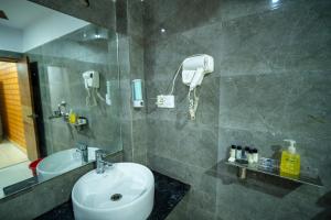 a bathroom with a sink and a shower with a phone at Hotel The Royal Buddha in Bodh Gaya +11 photos