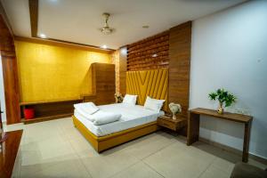 a bedroom with a bed and a yellow wall at Hotel The Royal Buddha in Bodh Gaya +11 photos