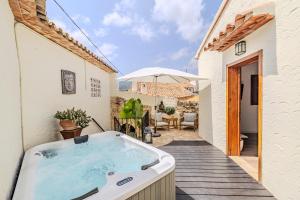 LliberCasa Rural Lliber的房屋甲板上的按摩浴缸