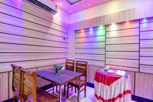 a dining room with a table and chairs and a wooden wall at Hotel O Mahal in Durgāpur +29 photos