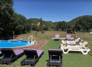 a group of lounge chairs and a swimming pool at La Bergerie Luxury cottage and pool on eco-friendly micro-farm in Duravel