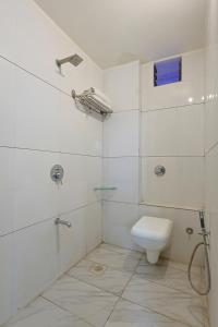 a white bathroom with a toilet and a shower at Hotel Gir Scintilla in Sasan Gir +47 photos