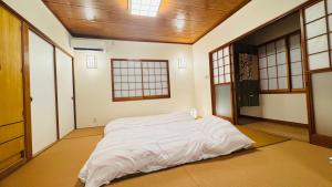 a large bed in a room with windows at KeiCo in Narusawa
