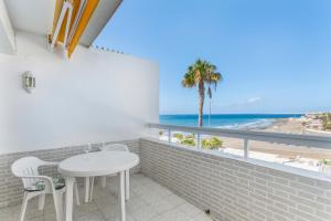 una mesa y sillas en una habitación con vistas a la playa en Al Mar en San Agustín, en San Bartolomé