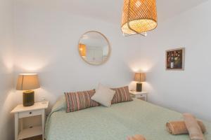 Un dormitorio con una cama con dos mesitas de noche y un espejo. en Al Mar en San Agustín, en San Bartolomé