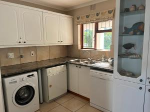 a kitchen with a washing machine and a sink at Jocks Place (on the sea) in Bettyʼs Bay +32 photos
