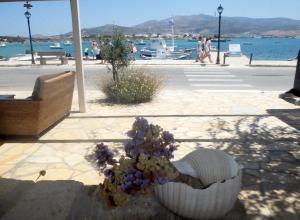 a bouquet of flowers in a white bowl on a beach at Hotel Mantalena in Antiparos Town