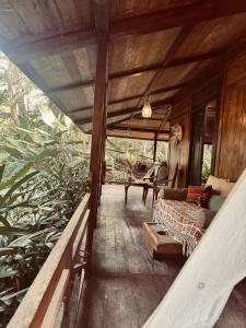 a porch of a house with a couch and a table at Resort JUNGLEROOM Canggu in Canggu