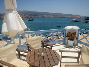 a table and chairs on a deck with the water at Hotel Mantalena in Antiparos Town