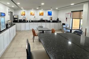 a restaurant with a counter and tables and chairs at Comfort Inn Dallas Park Central in Dallas