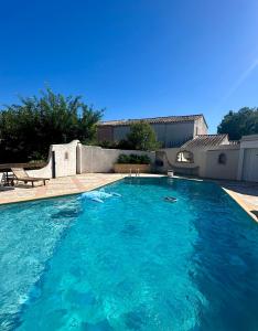 a large pool with blue water in a yard at Villa Victoire au coeur de la Provence in Venelles