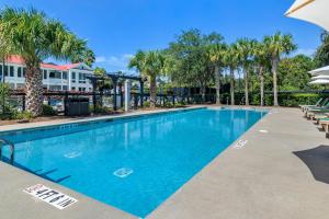 a swimming pool with trees and palm trees at Inn at I'On, an Ascend Collection Hotel in Charleston