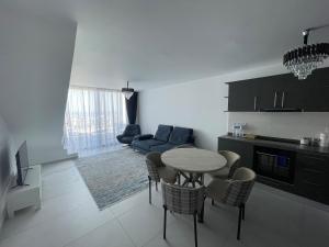a kitchen and living room with a table and chairs at Penthouse Blueberry in Kérynia