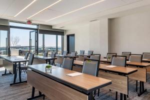 a conference room with tables and chairs and windows at Cambria Hotel Washington DC Navy Yard Riverfront in Washington